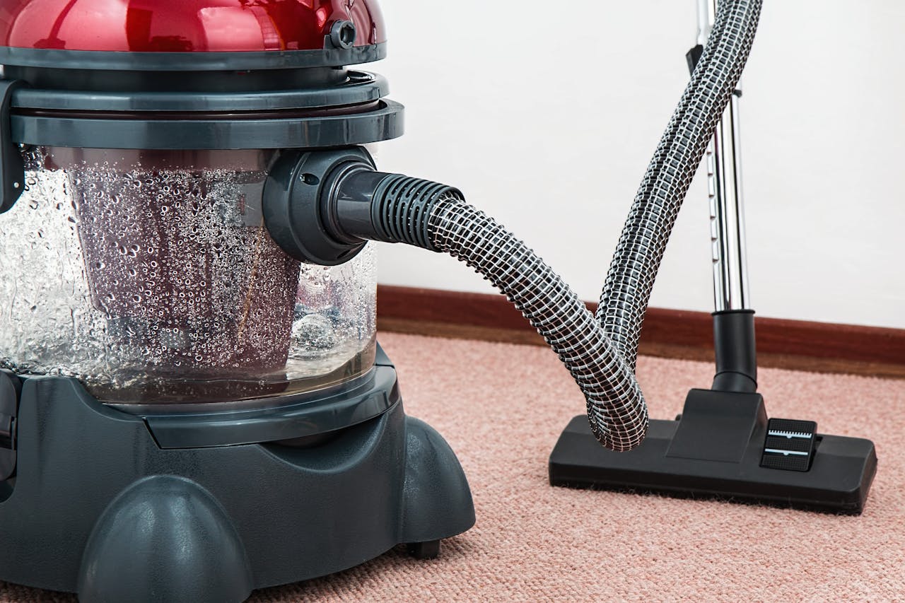 gallery-03 Close-up of a modern vacuum cleaner with water filtration on carpet floor indoors.
